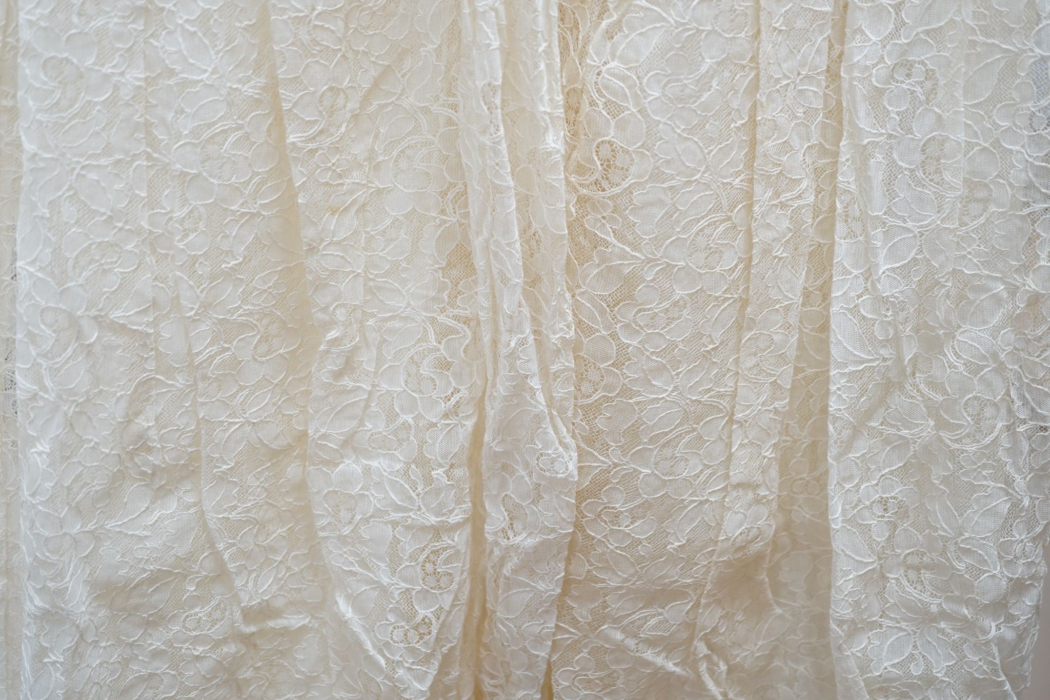 A late 1930's- 40's cream machine lace wedding dress and petticoat together with a pear listed floral tiara/ headdress.
